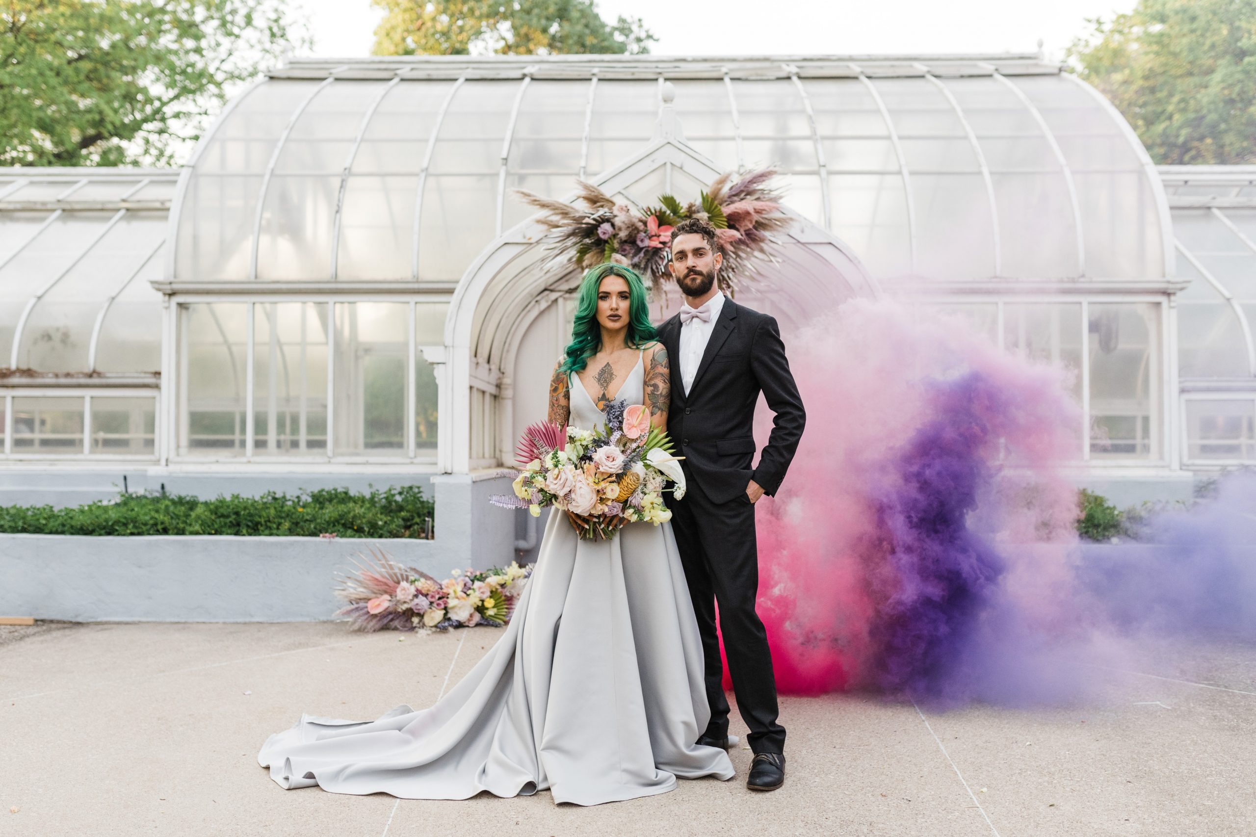 bride with green hair and groom in front of smoke bomb