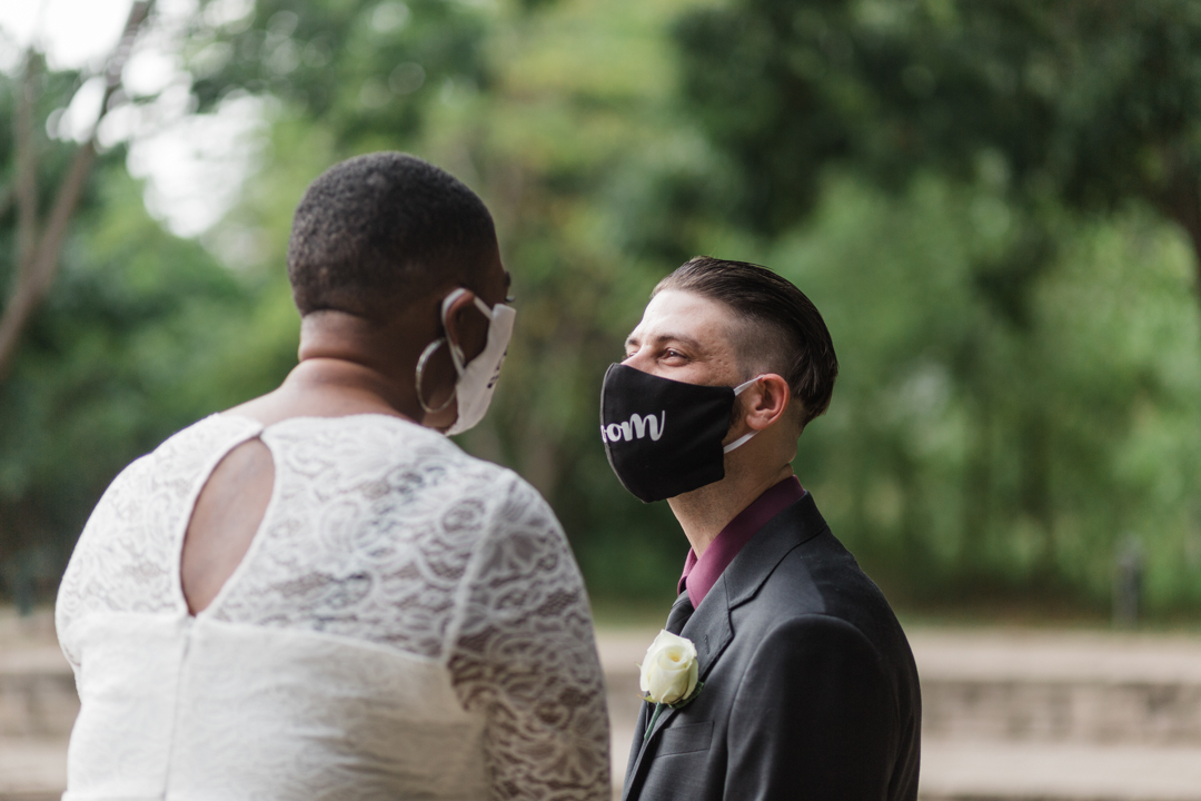 Bride and Groom masked and gazing at each other at their park elopement in DFW